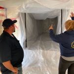 Two professionals assessing a room for asbestos removal.